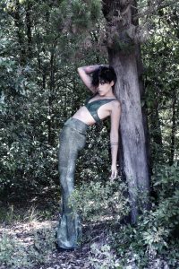 Fotografia fashion modella nella natura con pantaloni vintage