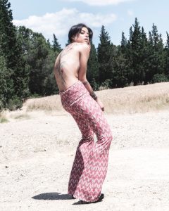 Fotografia fashion modella nella natura con pantaloni vintage